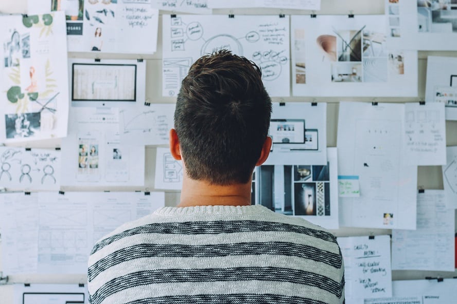 Person stnading in front of board with ideas for design
